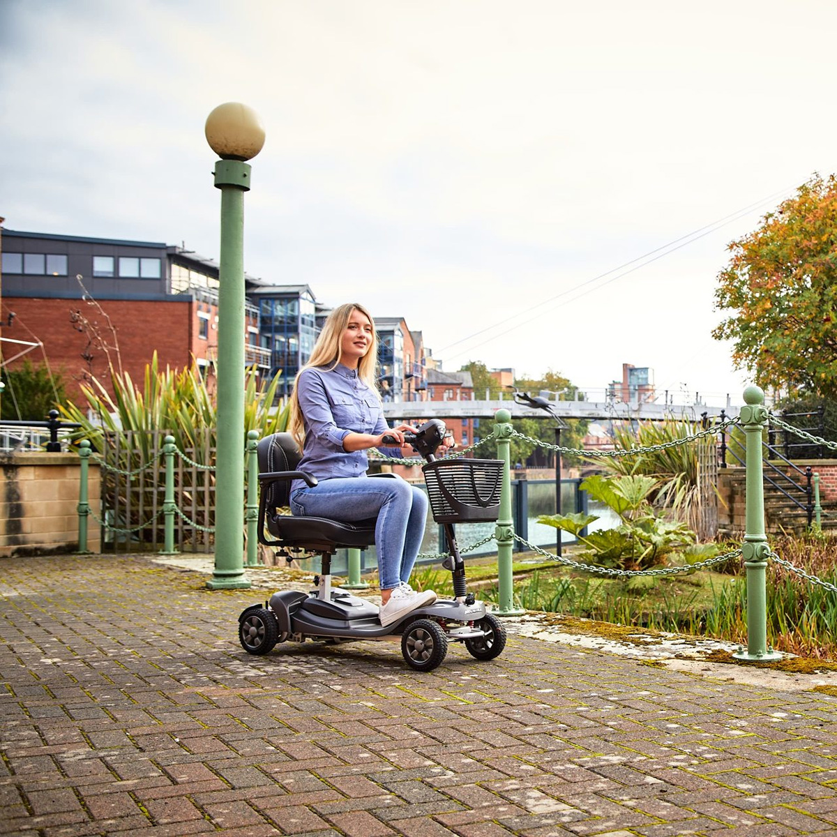 A lady riding on her lightweight aluminium Alumina Air Mobility Scooter with a lithium battery.jpg